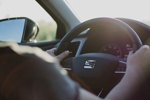 Person holding steering wheel